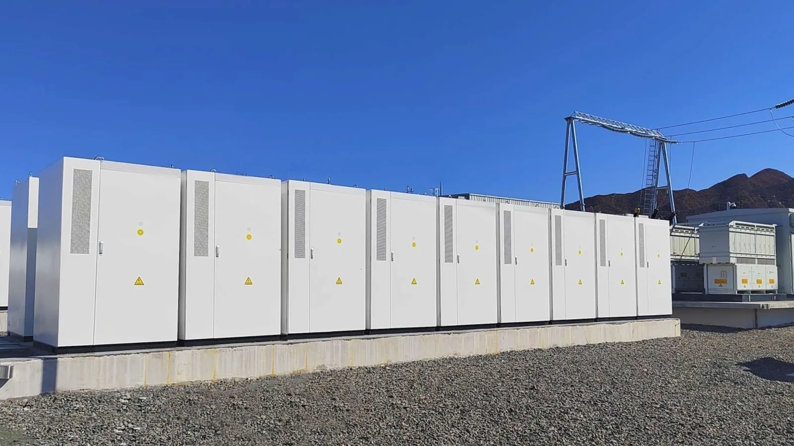 Row of BESS units next to a substation